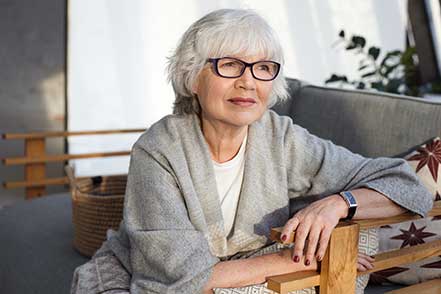 Photographie d'une femme age assise sur un canap